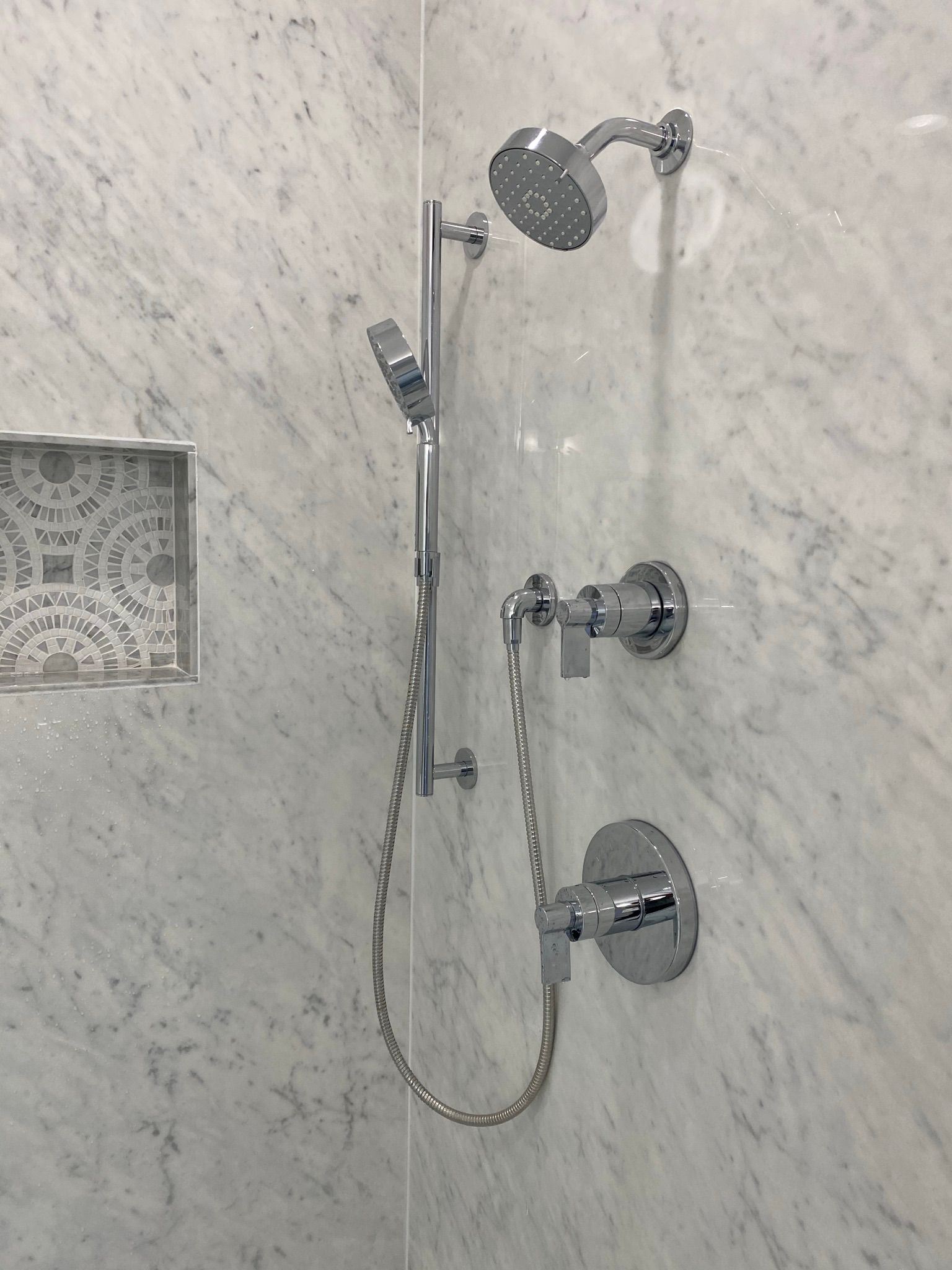 A close up of a shower head in a bathroom.