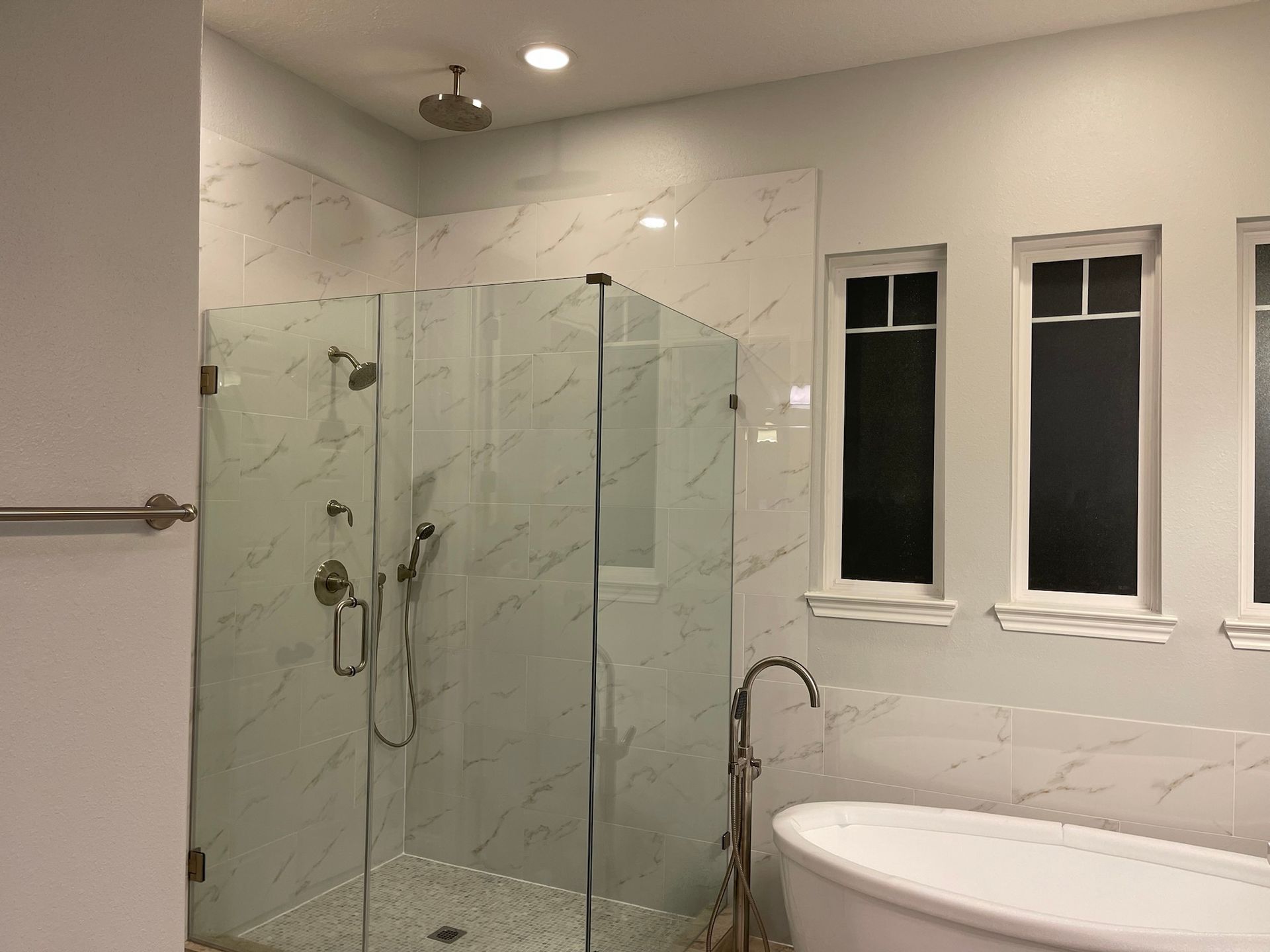 A bathroom with a walk in shower and a bathtub.