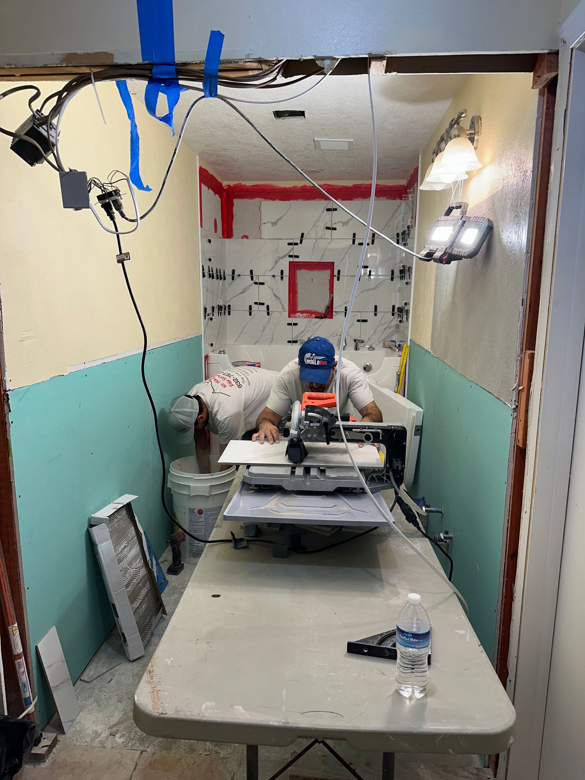 A man is sitting at a table in a room using a machine.