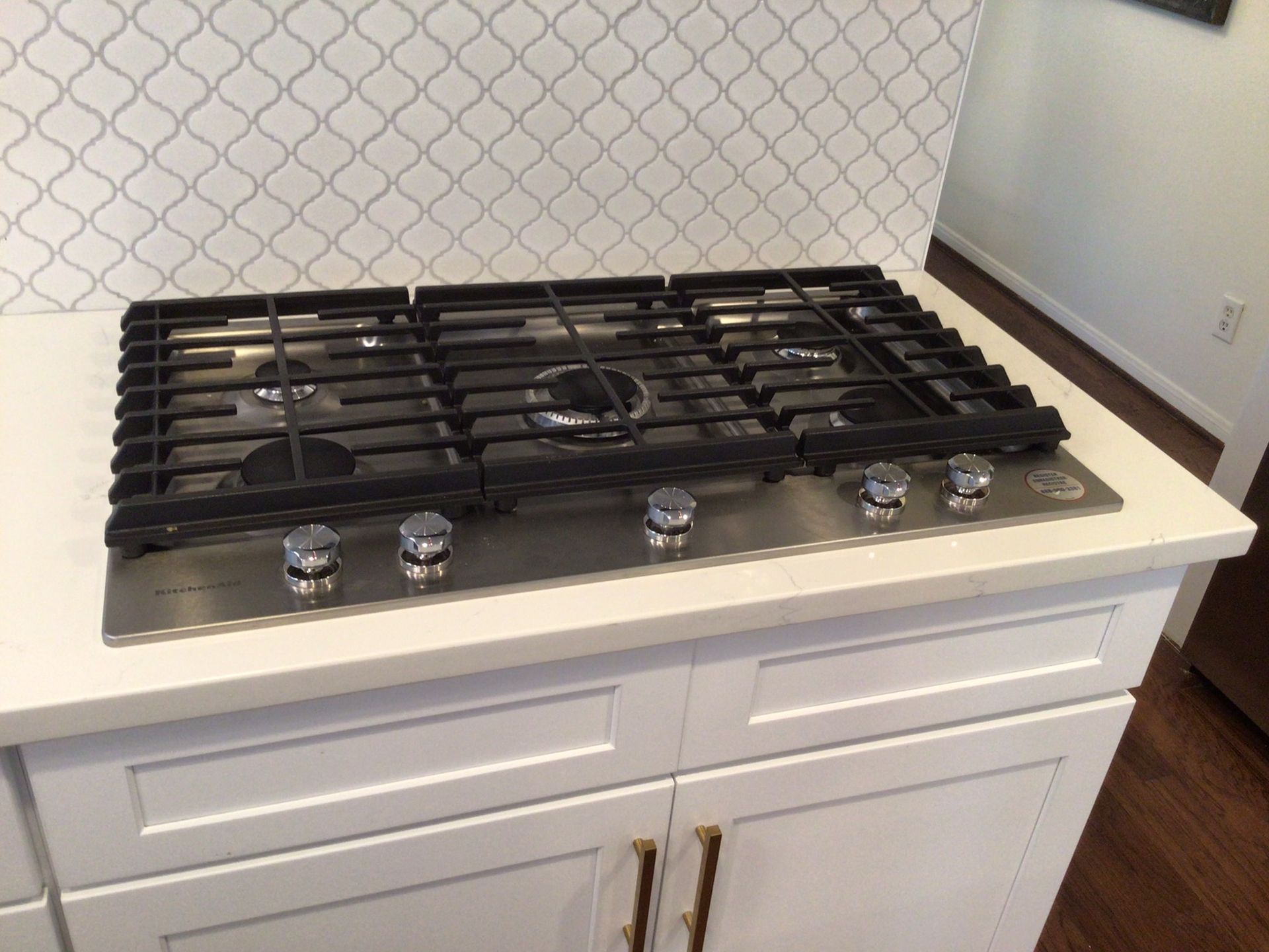 A stove top oven in a kitchen with white cabinets